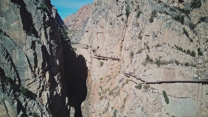 Narrow bridge between two steep mountains over the canyon