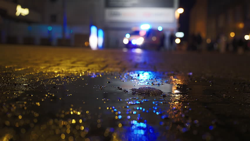 Thin focus: Night shot against a blurry ambulance with turned on flashing emergency siren lights in the rainy background | Shutterstock HD Video #1098653233