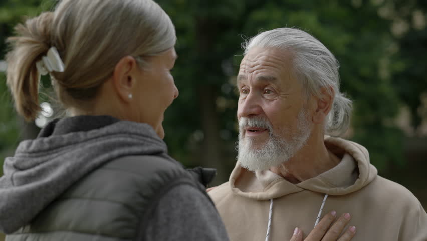 Close up of nice mature couple hugging standing in the park. Elderly family feeling inlove together. People and relationship concept