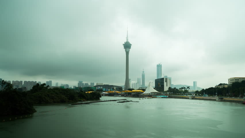 Wide shot timelapse of the Macau tower in a cloudy day. River by the bay scene. Concept of tourism.