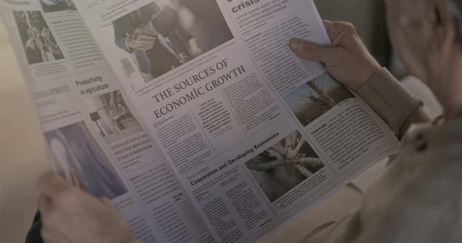 Old man reading the newspaper at home	