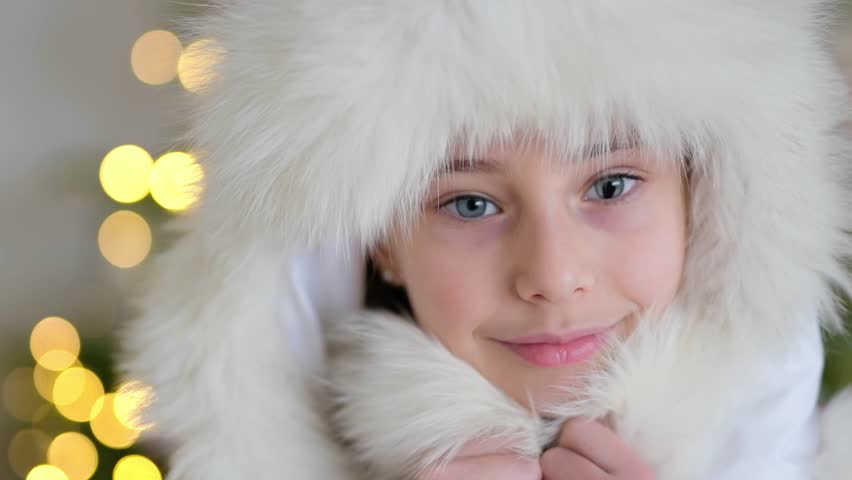 Slow motion video with a child in hat with fur, smiling little girl with koloboma on her eye