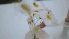 Close-up of festive wedding table setting with pastel wild flowers and spikelets at small cozy wedding party, slow motion. - Powered by Shutterstock - Get 15% off with code: PIKWIZARD15