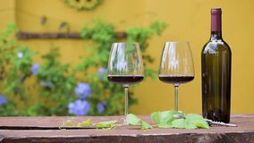 Hand hold glass to cheering and Drink glasses of red wine. Red wine pouring from bottle by winemaker to clear glass in vineyard vintage barrel winery. Pouring red wine into goblet on wood table  - Powered by Shutterstock - Get 15% off with code: PIKWIZARD15