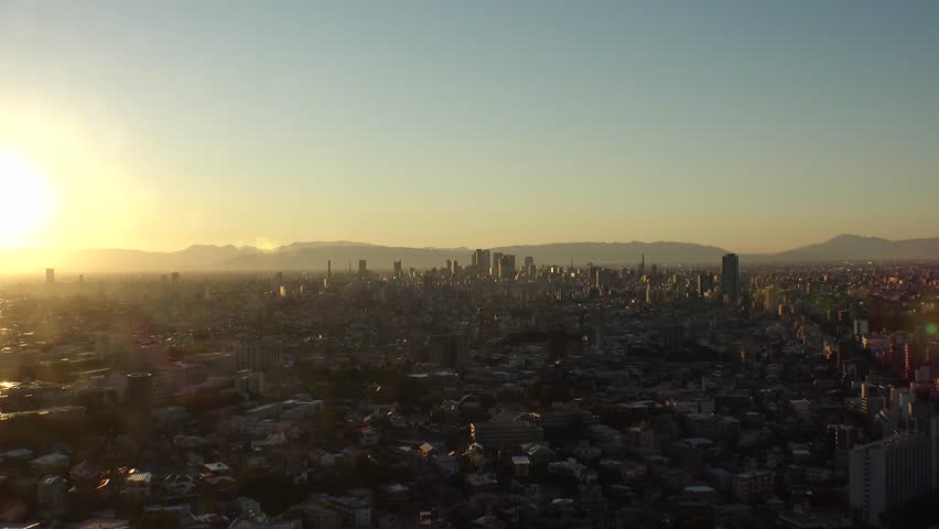 NAGOYA, JAPAN - OCT 2022 : Aerial high angle view of NAGOYA CITY in sunset. View of buildings and street traffic around Nagoya station and Sakae area (central downtown). Time lapse shot, dusk to night