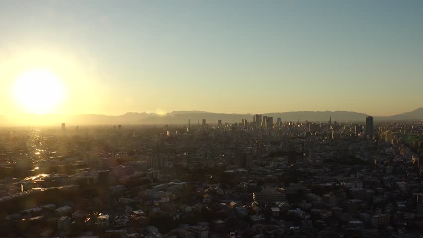NAGOYA, JAPAN - OCTOBER 2022 : NAGOYA CITY in sunset. Aerial high angle view of buildings and street traffic around Nagoya station and Sakae area (central downtown). Time lapse shot, dusk to night.