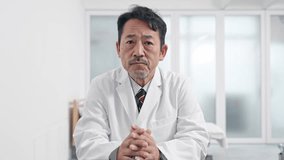 Middle aged Asian doctor talking with video call.