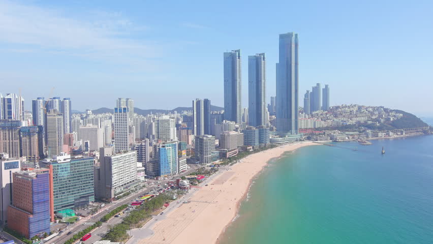 Busan: Aerial view of city in South Korea, skyline with modern high-rise buildings (skyscrapers) and Haeundae Beach, sunny day with blue sky - landscape panorama of Eastern Asia from above