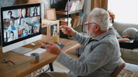 Cheerful old retired man enjoying a multi video call with friends using a computer while in the background his grandson is lying on a sofa and listening music on a laptop - Powered by Shutterstock - Get 15% off with code: PIKWIZARD15