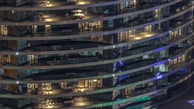 Outside view of windows in apartments of a high class building at night timelapse. Glowing lights in skyscraper. Chairs on balconies - Powered by Shutterstock - Get 15% off with code: PIKWIZARD15