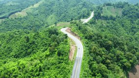 Aerial footage of winding road in rainy season on tropical rainforest mountain in Nan province, Thailand.