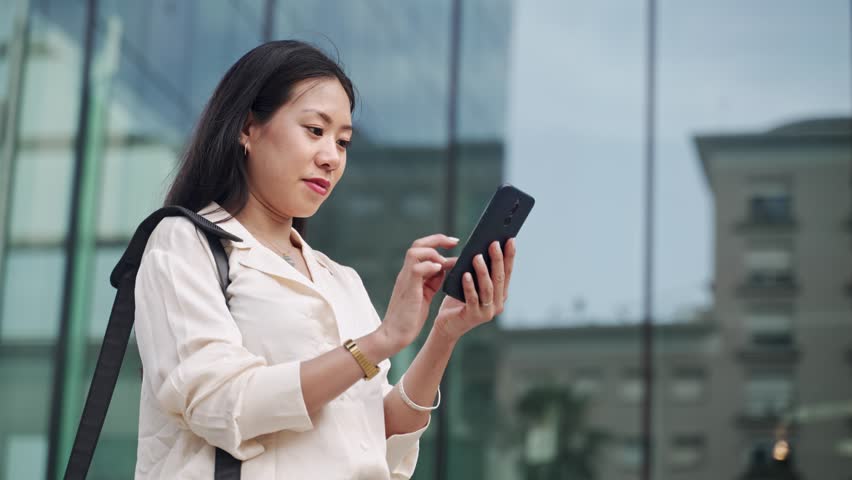Young Asian Elegant Professional Business Woman using cell smart phone outside the office | Shutterstock HD Video #1098726969
