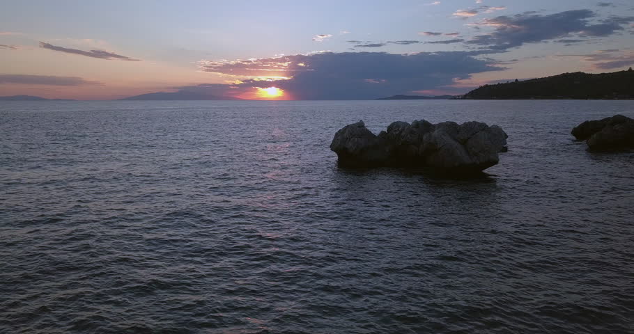 Aerial view of a rocky shore of the Aegean Sea at sunset in Greece