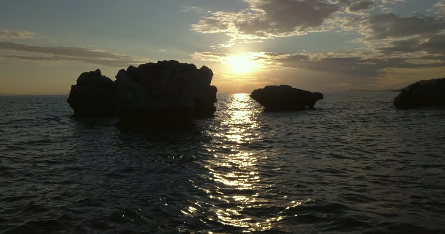 Aerial view of a rocky shore of the Aegean Sea at sunset in Greece