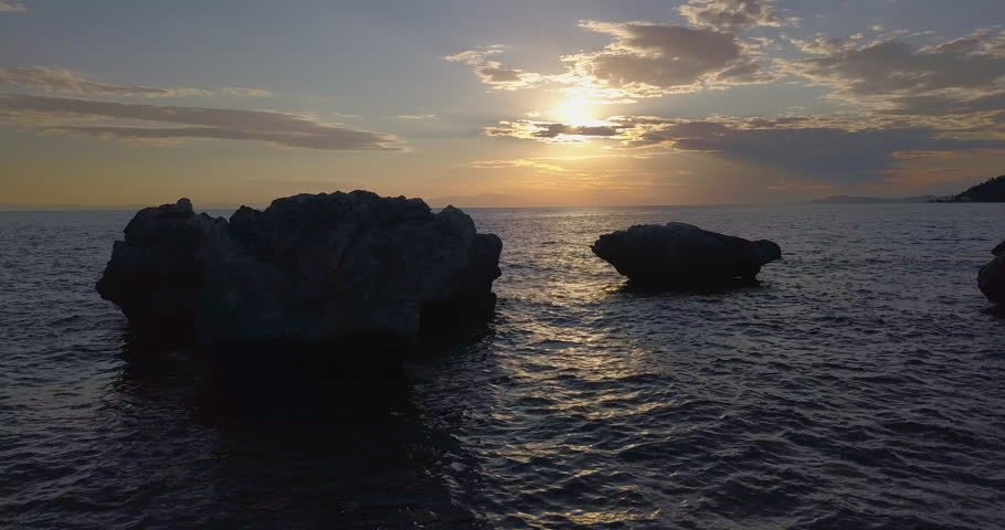 Aerial view of a rocky shore of the Aegean Sea at sunset in Greece