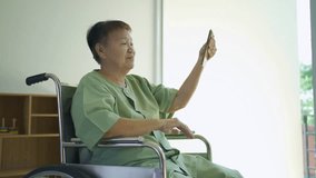 Portrait of happy smiling Asian sick old female senior elderly patient using a technology smartphone device to talk online , woman person in hospital in medical healthcare concept. People lifestyle.