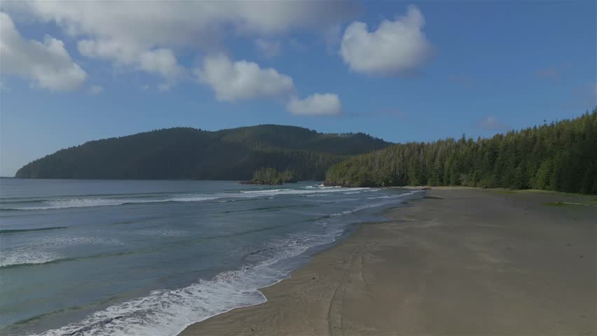 Sandy beach on Pacific Ocean Coast View. Sunny Blue Sky. San Josef Bay, Cape Scott Provincial Park, Northern Vancouver Island, BC, Canada. Canadian Nature Background. Cinematic 4k