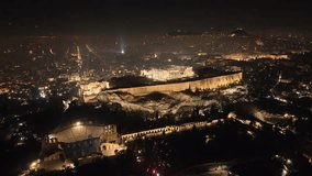 Aerial drone night video of iconic illuminated landmark Acropolis hill and the Masterpiece of Ancient times and Western civilisation - the Parthenon, Athens, Attica, Greece