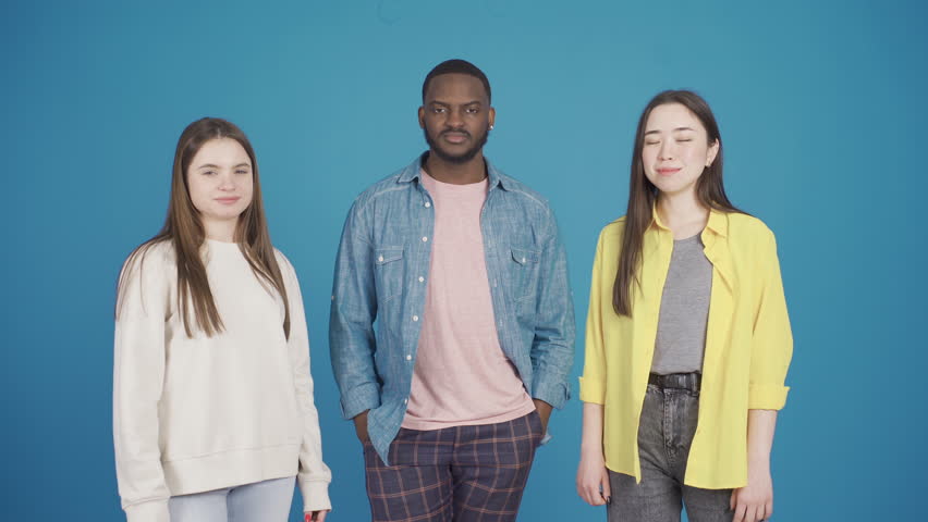 Group of three multiethnic model friends dancing while looking at camera, shaking their heads at the beat. Fashion design.
Happy and smiling multiethnic group of friends dancing, having fun and lookin