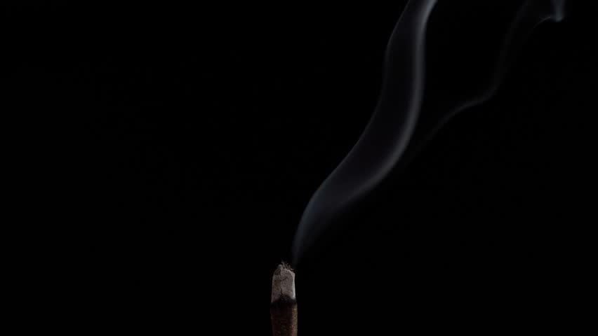 Clouds of fragrant smoke from a smoldering stick of incense for meditation, yoga and relaxation on a black background | Shutterstock HD Video #1098746191