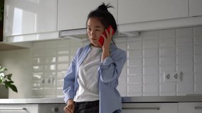 Young surprised Asian woman talking by phone while standing in kitchen at home, excited female holding smartphone hearing unexpected shocking news, getting phone call. Mobile communication concept - Powered by Shutterstock - Get 15% off with code: PIKWIZARD15