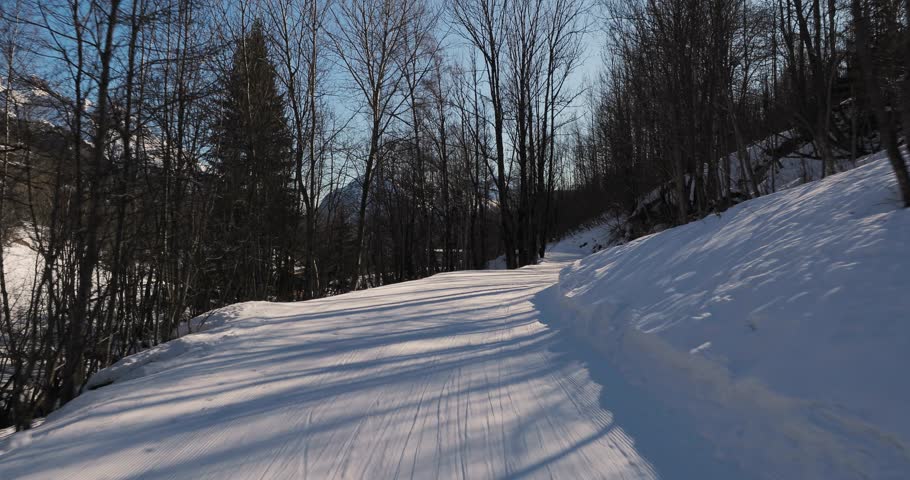 Skiing in the alps, slow, easy slope, realxing ride, forst person point of view, slow motion from 4k 60p footage, sunlight flares