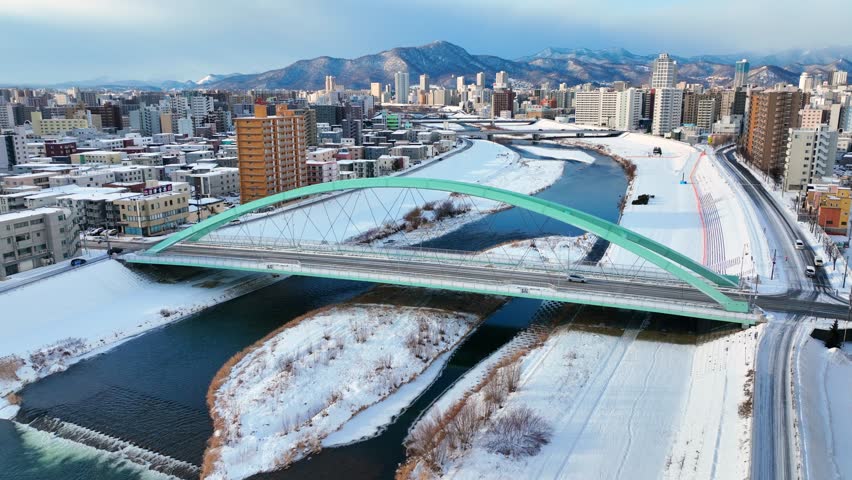 winter aerial view of Sapporo, Hokkaido, northern Japan, flying above frozen river in downtown Sapporo. High quality 4k footage