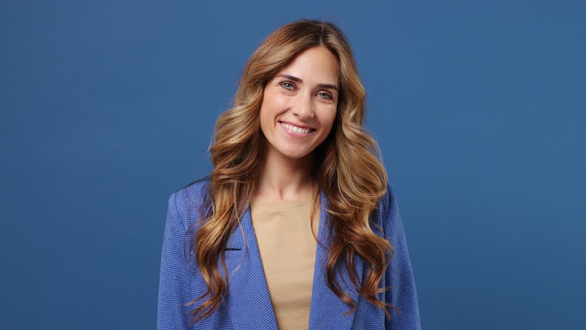 Young happy fun cool cheerful caucasian woman wearing suit jacket beige t-shirt looking camera smiling isolated on plain dark royal navy blue color background studio portrait. People lifestyle concept