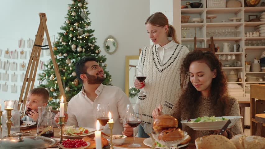 Concentrated multinational family celebrating Christmas and talking at home | Shutterstock HD Video #1098764663