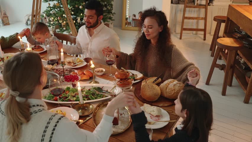 A handsome multicultural family prays while celebrating Christmas at home | Shutterstock HD Video #1098764723