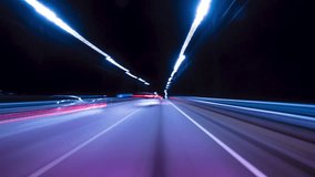 Bright Motion Hyperlapse of a Speedy Night Drive in a Big City, Windshield View. Speedy Car Driving the Highway With a Lot of Lights and Traffic, Passing by City Buildings Along the Road