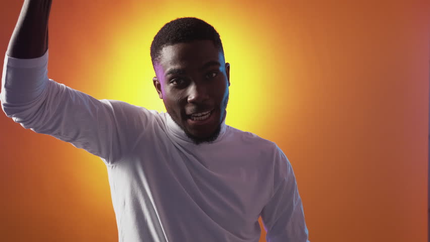 Fan support. Victory celebration. Champion league. Encouragement greeting. Excited proud satisfied man raising clenched fists on orange.