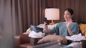 happiness asian female adult woman 
 preparing travel trip packing wearing casual cloth enjoy unpack suitcase luggage and video calling with her friend joyful laugh smile travel and vacation concept