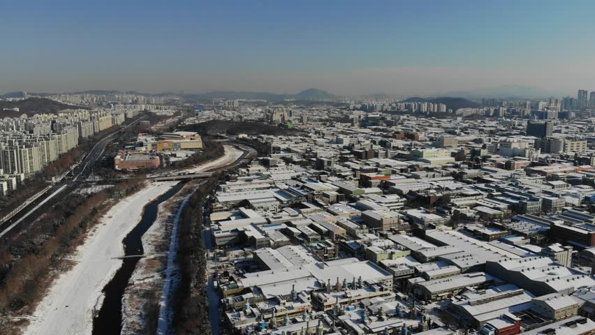 Aerial view of drainage canal in Namdong-gu industrial estate in winter, snowy day of Incheon city, South Korea. Royalty-Free Stock Footage #1098776175
