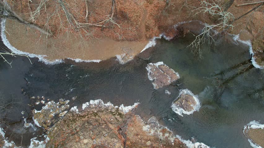 Drone shot of a flowing winter creek