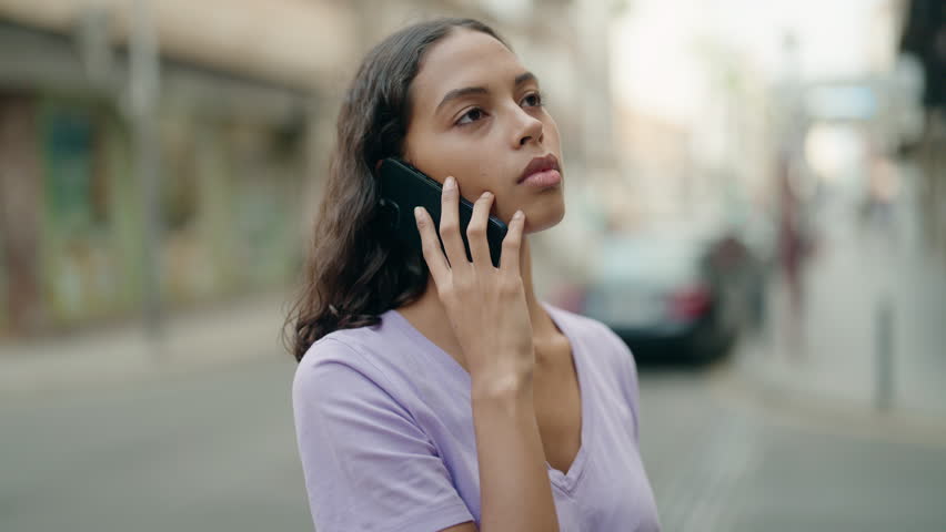Young african american woman talking on smartphone with worried expression at street | Shutterstock HD Video #1098778979