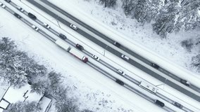 The truck rides slowly in a traffic jam in winter after a snowfall. Aerial view
