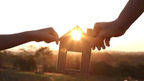 Mother and daughter hands holding paper house, home together silhouette against sunset with soft focus. Concept of Happy Family, Buy House, Home, life, insurance, care, saving, mortgage, estate - Powered by Shutterstock - Get 15% off with code: PIKWIZARD15