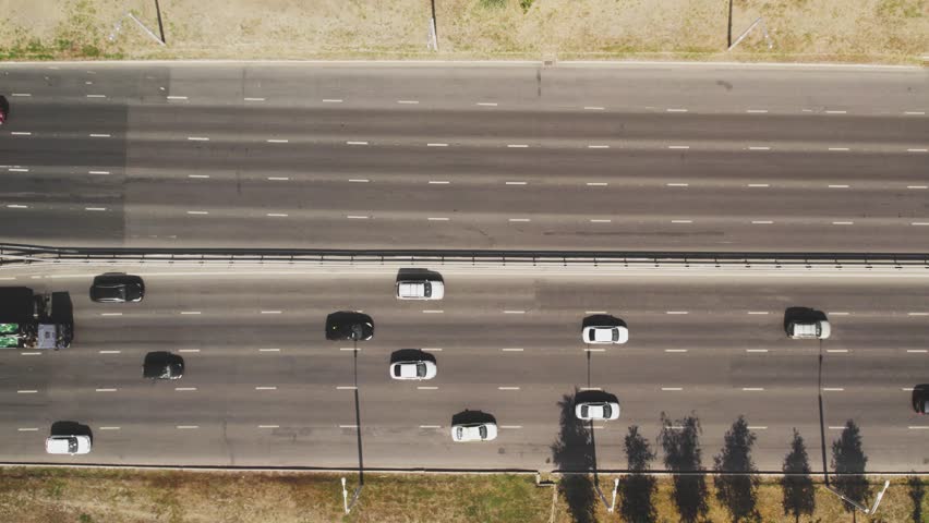 View from the top to the highway. 4K aerial drone shooting of a multi-lane road with moving vehicles. Car traffic in a big city Royalty-Free Stock Footage #1098782531