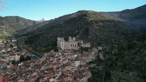 4k aerial drone video of Dolceacqua, Italy , medieval mountain village, its chateau, castel, ruines, fort next to river and a small ancient bridge