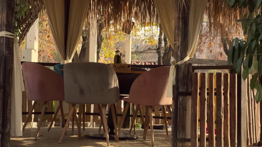 Close up of empty cozy gazebo in restaurant with garden. Enjoying nice autumn weather in outdoor restaurant in Plovdiv, Bulgaria.