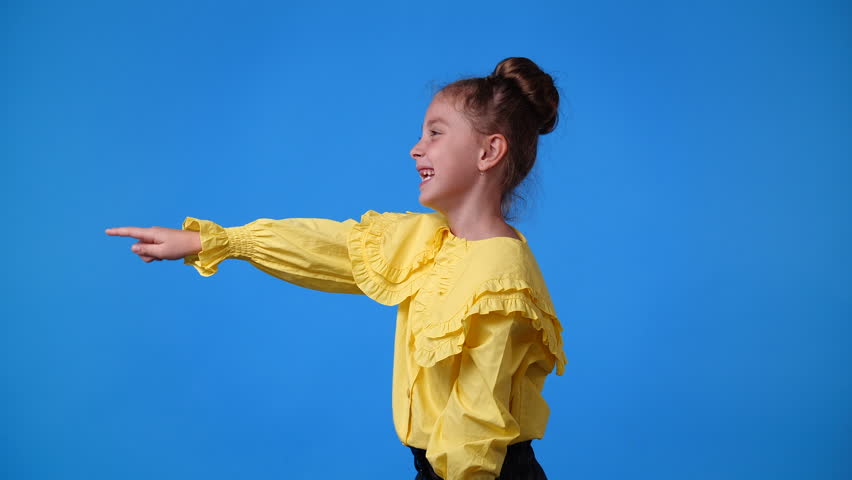 4k slow motion video of one girl pointing at left and smiling over blue background. | Shutterstock HD Video #1098797495