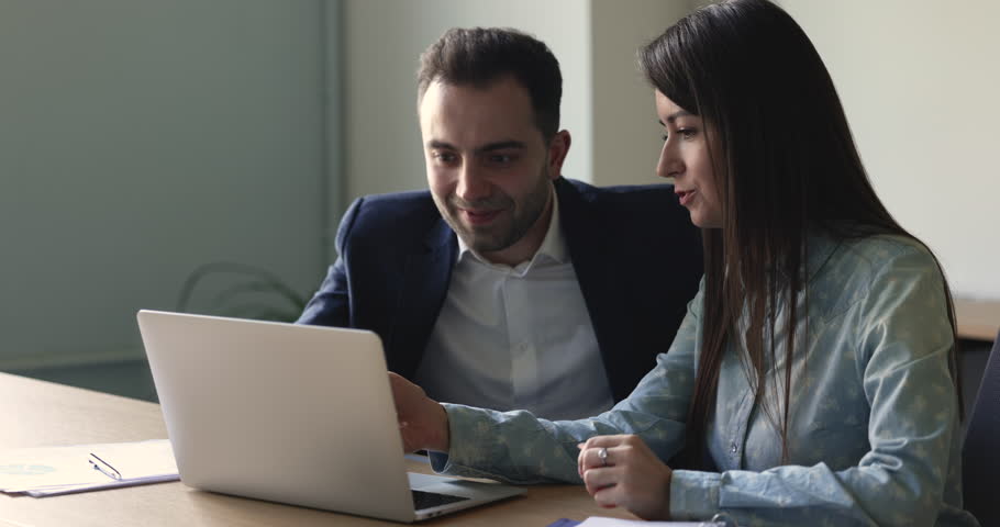 Teamwork, mentoring, workflow using modern wireless tech. Two millennial colleagues working together on on-line project, share ideas, solve common business, engaged in cooperation in company office | Shutterstock HD Video #1098801637