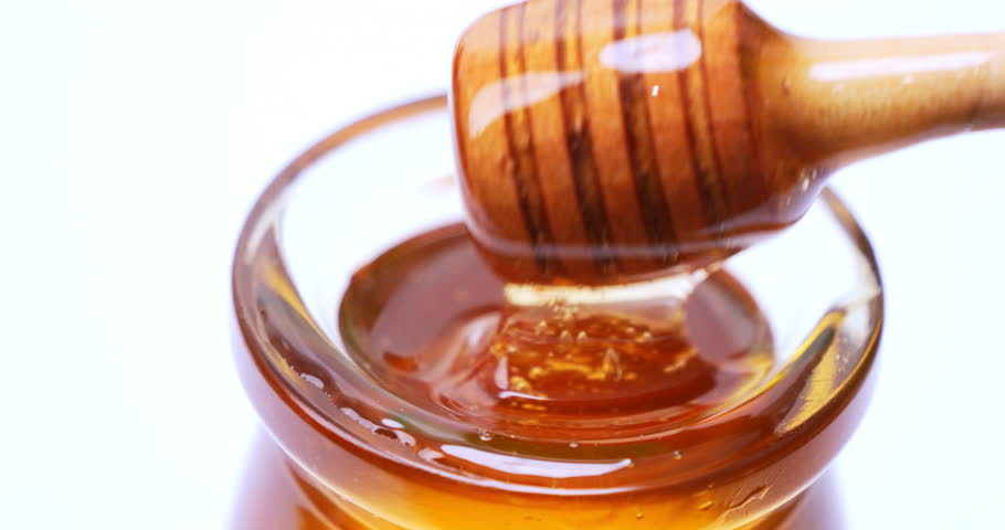 Close-up shot of dipping honey with a honey scoop in a glass bowl. Royalty-Free Stock Footage #1098802829