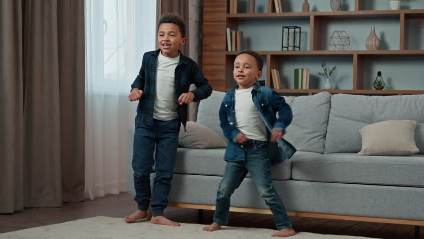 Ethnic African American multiethnic boys kids schoolboys pupils sons indoors children brothers friends dancing to song listen music celebrate party at home funny dance watching TV moving having fun Royalty-Free Stock Footage #1098804019