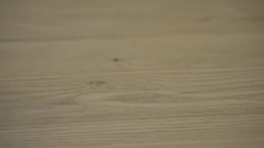 Vintage toy train engine and caboose rolling across a wooden floor - isolated close up