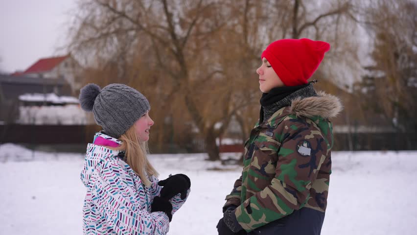 Dissatisfied teenage couple arguing outdoors turning from each other crossing hands looking away. Unsatisfied Caucasian teen boy and girl quarreling in winter park outdoors. Slow motion