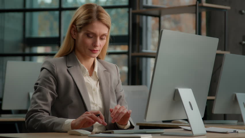 Caucasian middle-aged adult woman dancing listening music at workplace sing song to pen like microphone. Business lady businesswoman entrepreneur worker in office funny dance singing to computer audio Royalty-Free Stock Footage #1098812389