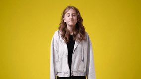 4k slow motion video of one girl posing for a video over yello background.