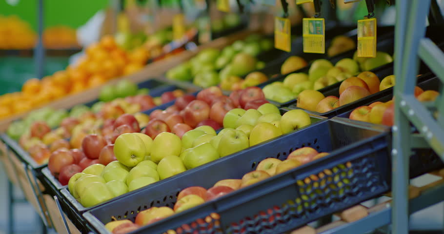 man customer choosing ripe apples from shelf in supermarket, closeup view, 4K, Prores